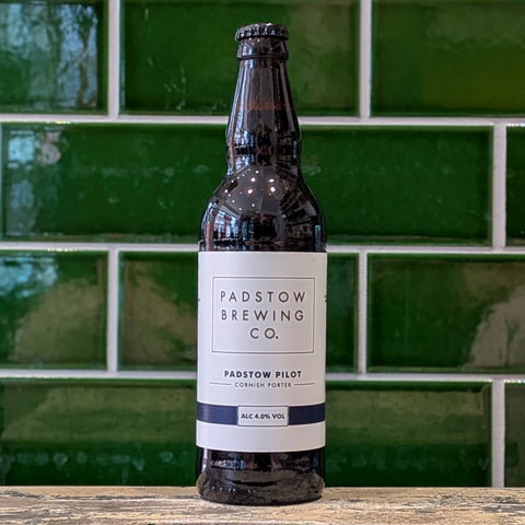 Bottle of Padstow Brewing Co. Padstow Pilot Cornish Porter against a green tiled wall.